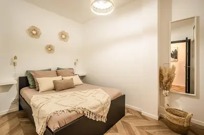 a bedroom with a bed and a mirror at L'Appart Central - Chic et Confort in Narbonne
