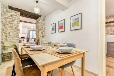 a dining room with a wooden table and chairs at Au Pied de la Cité - Terrasse - Climatisation - Wifi in Carcassonne