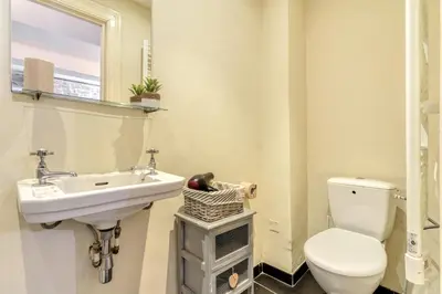 a bathroom with a white toilet and a sink at Au Pied de la Cité - Terrasse - Climatisation - Wifi in Carcassonne