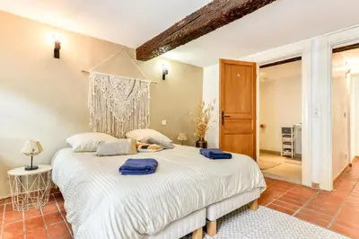a bedroom with a large white bed in a room at Au Pied de la Cité - Terrasse - Climatisation - Wifi in Carcassonne