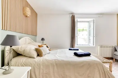a bedroom with a large bed with a lamp on it at Au Pied de la Cité - Terrasse - Climatisation - Wifi in Carcassonne