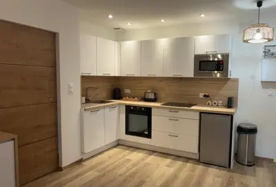 a kitchen with white cabinets and a stove top oven at Le petit narbonnais in Narbonne