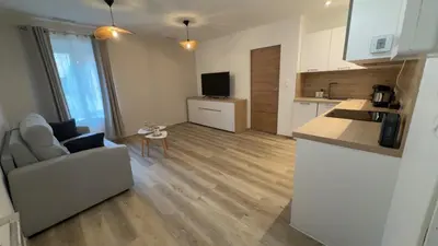 a kitchen and living room with a couch and a table at Le petit narbonnais in Narbonne