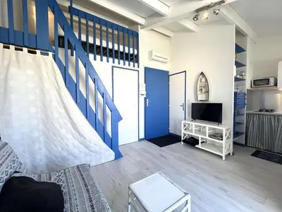 a living room with a blue and white wall at Appartement La Pinède avec Terrasse, clim et parking - GN320-124 in Gruissan