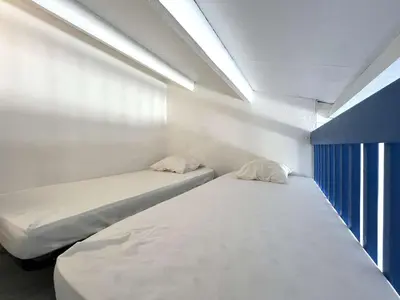 two beds in a small room with a window at Appartement La Pinède avec Terrasse, clim et parking - GN320-124 in Gruissan