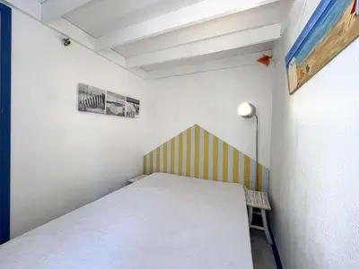 a small room with a bed and a lamp at Appartement La Pinède avec Terrasse, clim et parking - GN320-124 in Gruissan