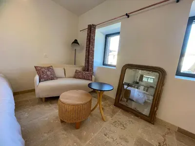 a living room with a mirror and a couch at La Métairie du Château Paul in Aussillon