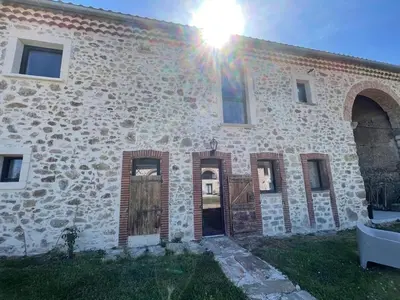 a stone building with the sun shining on it at La Métairie du Château Paul in Aussillon