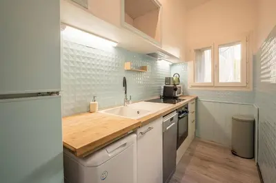 a kitchen with a sink and a counter top at Cocon des halles - Climatisation - Terrasse in Narbonne