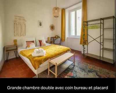 a bedroom with a large bed with a yellow blanket at Cocon des halles - Climatisation - Terrasse in Narbonne