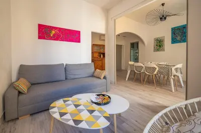 a living room with a couch and a table at Cocon des halles - Climatisation - Terrasse in Narbonne
