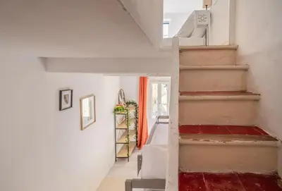 a staircase in a home with white walls and red carpet at Cocon des halles - Climatisation - Terrasse in Narbonne
