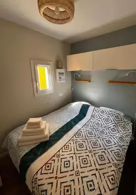 a bedroom with a bed with towels on it at Superbe Appartement T2 climatisé in Gruissan