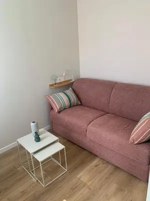 a living room with a couch and a table at Superbe Appartement T2 climatisé in Gruissan