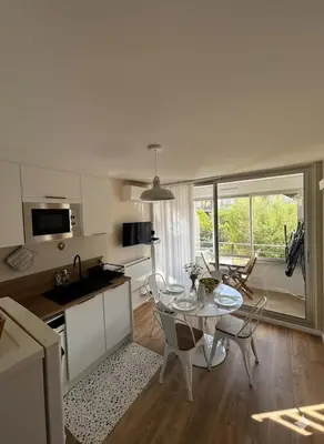 a kitchen and living room with a table and chairs at Superbe Appartement T2 climatisé in Gruissan