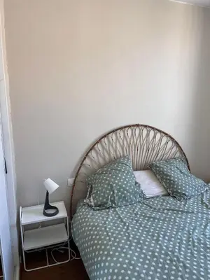 a bedroom with a bed with a lamp on a nightstand at Casa Colori - Charmant T2 in Carcassonne