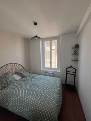 a bedroom with a bed and a window at Casa Colori - Charmant T2 in Carcassonne