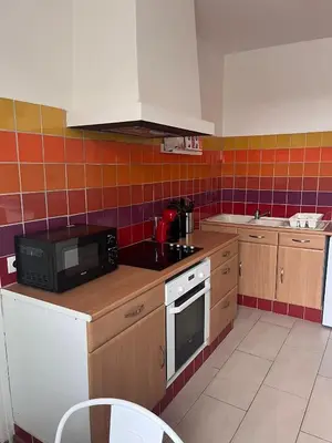 a kitchen with a microwave and a stove top oven at Casa Colori - Charmant T2 in Carcassonne