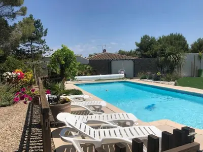 a swimming pool with white chairs and a swimming pool at Les Oliviers in Villemoustaussou