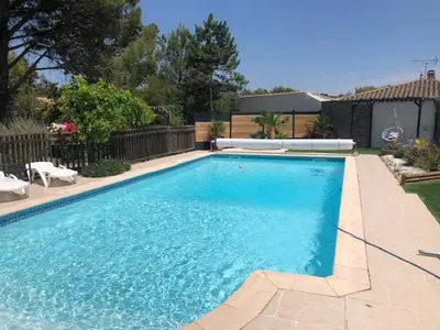 a large blue swimming pool in a yard at Les Oliviers in Villemoustaussou