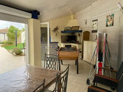 a living room with a table and a kitchen at Les Oliviers in Villemoustaussou