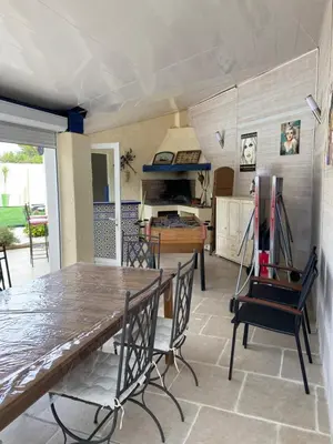 a dining room with a wooden table and chairs at Les Oliviers in Villemoustaussou