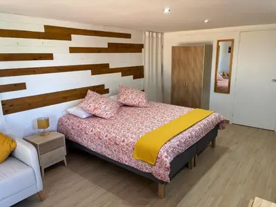 a bedroom with a bed with a wooden wall at The Studio at Gites 474 in Sallèles-dʼAude