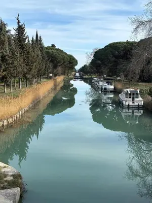 a river with boats docked in the water at The Studio at Gites 474 in Sallèles-dʼAude