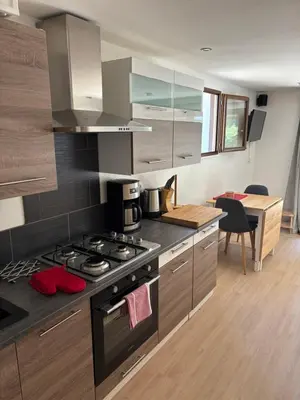 a kitchen with a stove top oven next to a table at The Studio at Gites 474 in Sallèles-dʼAude