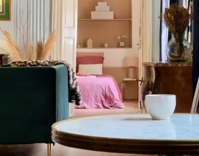 a living room with a table and a bed at Puddington Abbey by Art&Suites Élégant XVIIIe 80m privatif Centre ville Calme et douceur de vivre in Narbonne