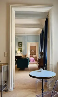 a living room with a table and a bedroom at Puddington Abbey by Art&Suites Élégant XVIIIe 80m privatif Centre ville Calme et douceur de vivre in Narbonne