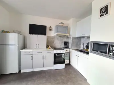 a kitchen counter with a towel and a laptop at Cocon du Lac 4 couchages 500m à pied des plages in Port-la-Nouvelle
