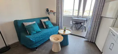 a kitchen with white cabinets and a black stove top oven at Cocon du Lac 4 couchages 500m à pied des plages in Port-la-Nouvelle