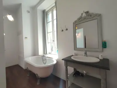 a bathroom with a tub and a sink and a mirror at Suite de Rêve au Château avec Bain Caché - Accès Bassin de Nage - Clim in La Redorte