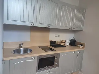 a kitchen with white cabinets and a sink at Suite de Rêve au Château avec Bain Caché - Accès Bassin de Nage - Clim in La Redorte
