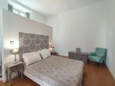 a bedroom with a bed and a blue chair at Suite de Rêve au Château avec Bain Caché - Accès Bassin de Nage - Clim in La Redorte