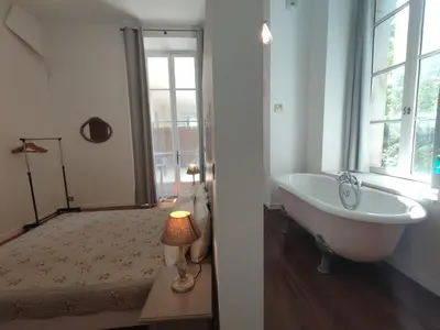 a white bath tub in a room with a window at Suite de Rêve au Château avec Bain Caché - Accès Bassin de Nage - Clim in La Redorte