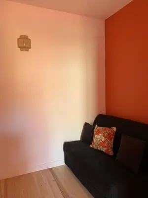a living room with a black couch against a wall at Maison de ville centre de Narbonne Amardeil in Narbonne