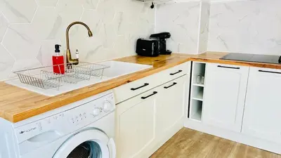 a kitchen with a washing machine and a sink at Studio Chanzy lumineux cozy avec terrasse Narbonne in Narbonne