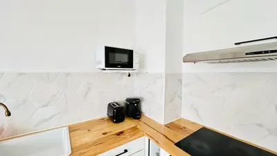 a kitchen with a counter with a tv on the wall at Studio Chanzy lumineux cozy avec terrasse Narbonne in Narbonne
