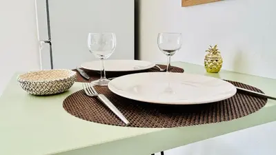 a table with two plates and wine glasses on it at Studio Chanzy lumineux cozy avec terrasse Narbonne in Narbonne