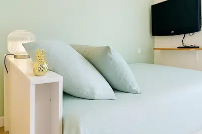 a bed with blue pillows and a television on it at Studio Chanzy lumineux cozy avec terrasse Narbonne in Narbonne