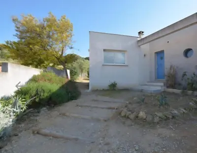 a white house with a blue door at Villa Alfabeta in Bizanet