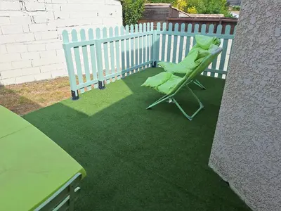a green frog sitting in a chair on a lawn at Villa Alfabeta in Bizanet