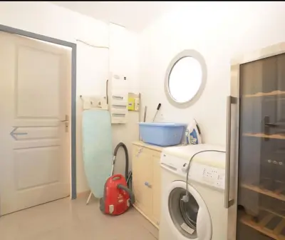 a laundry room with a washing machine and a mirror at Villa Alfabeta in Bizanet