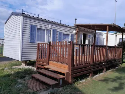 a small house with a porch and a deck at Mobilhome tout confort in Port-la-Nouvelle