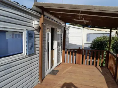 a porch of a house with a wooden deck at Mobilhome tout confort in Port-la-Nouvelle