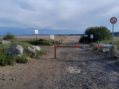 a gate on the side of a dirt road at Mobilhome tout confort in Port-la-Nouvelle