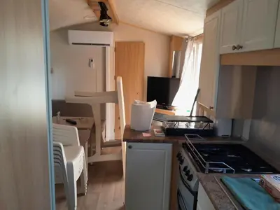 a small kitchen with a stove and a counter top at Mobilhome tout confort in Port-la-Nouvelle