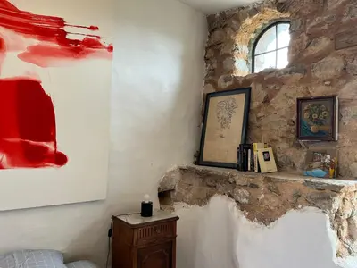 a bedroom with a stone wall with a bed and a window at Chateau Fitou Presbytery in Fitou